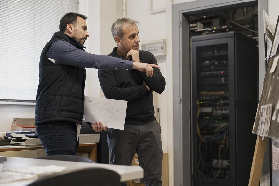 Due tecnici valutano un impianto e la relativa documentazione